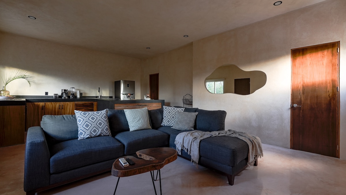Living room with L-shaped sofa and kitchenette